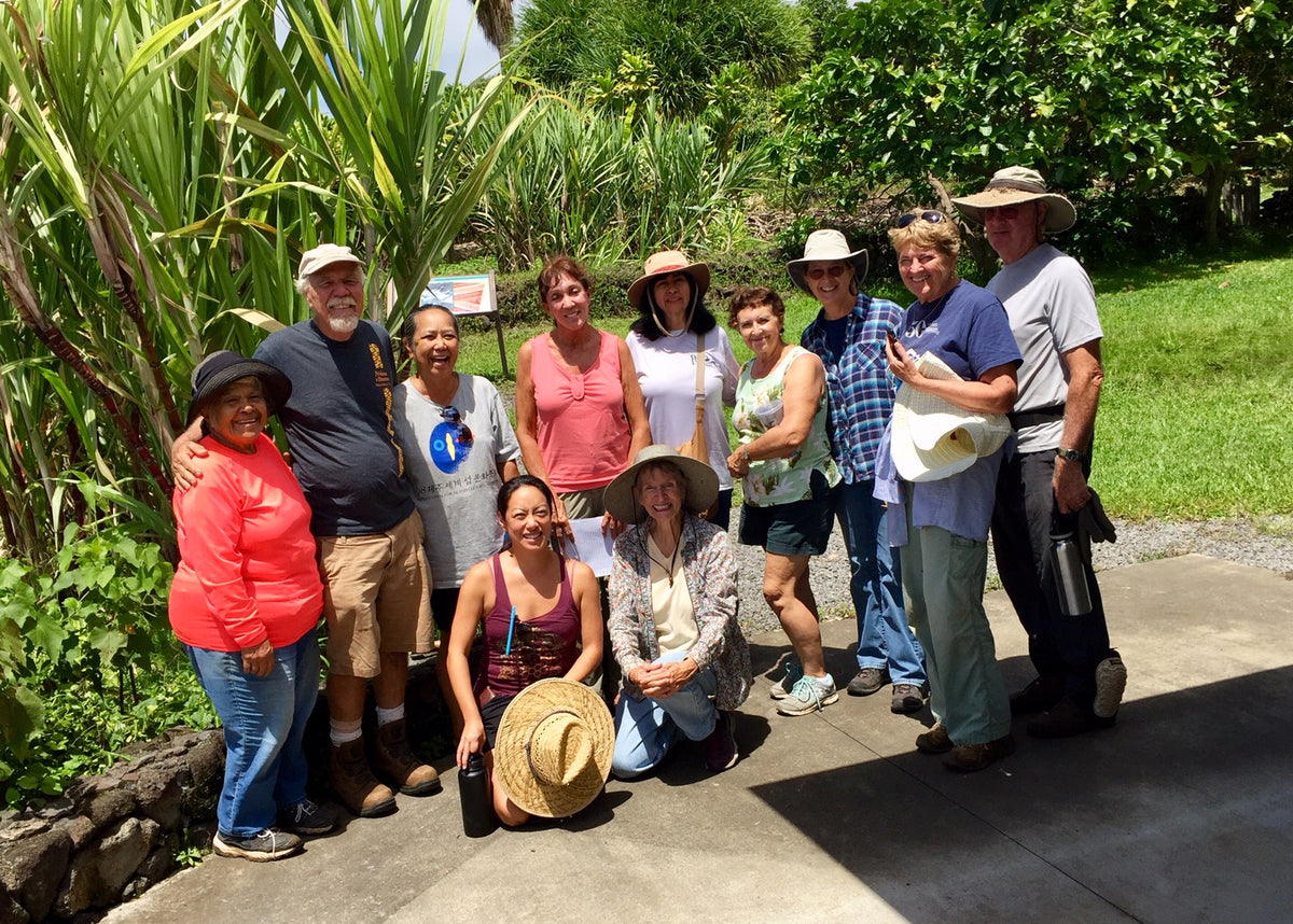 Group of people posing outdoors with greenery in the background