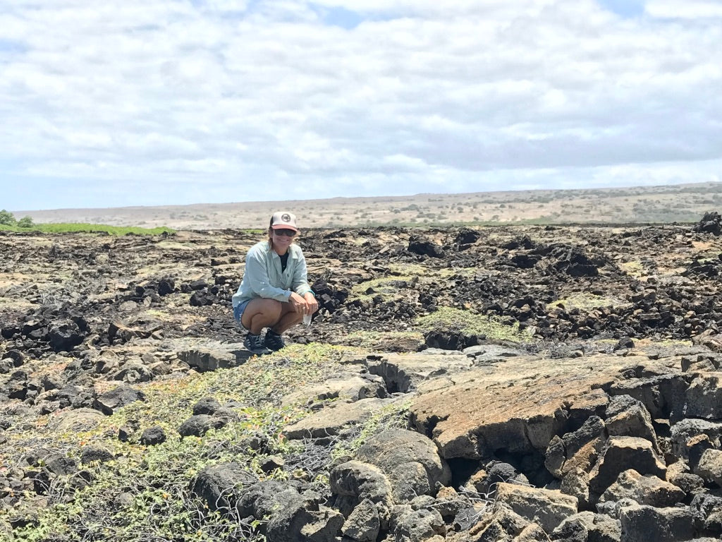 Person sitting on a rocky landscape with a clear sky